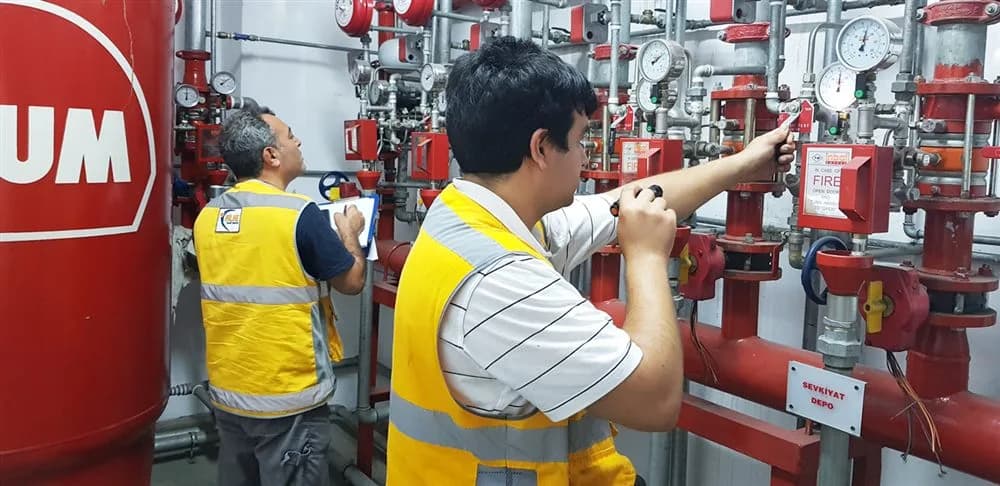 Sahada yangın söndürme sistemi üzerinde periyodik kontrol yapan mühendis